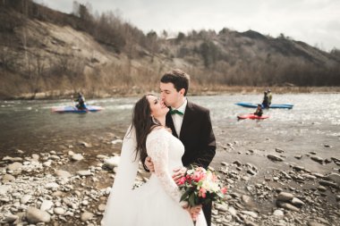 Mutlu evlilik çift, gelin ve damat zemin Dağları nın karşı temiz nehir poz