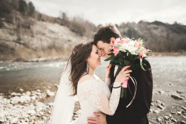 Mutlu evlilik çift, gelin ve damat zemin Dağları nın karşı temiz nehir poz