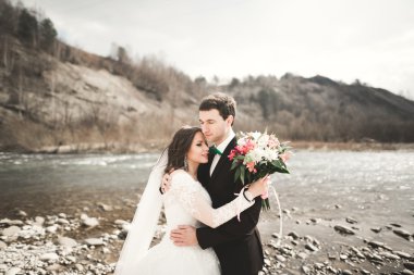 Mutlu evlilik çift, gelin ve damat zemin Dağları nın karşı temiz nehir poz