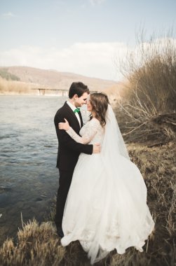 Mutlu yeni evliler, gelin ve damat nehir manzarası ile poz