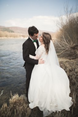 Mutlu yeni evliler, gelin ve damat nehir manzarası ile poz