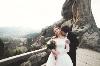 Mutlu evlilik çift, gelin ve damat kayalar güzel manzaralı yakınındaki poz