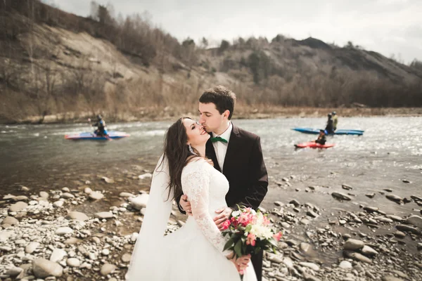 Mutlu evlilik çift, gelin ve damat zemin Dağları nın karşı temiz nehir poz