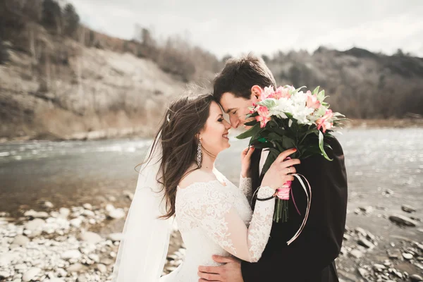 Mutlu evlilik çift, gelin ve damat zemin Dağları nın karşı temiz nehir poz