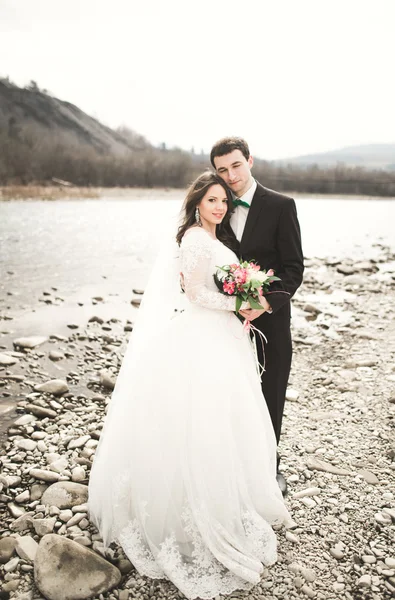 Pár boldog esküvő, a menyasszony és a vőlegény jelentő ügyes folyó a hegység — Stock Fotó