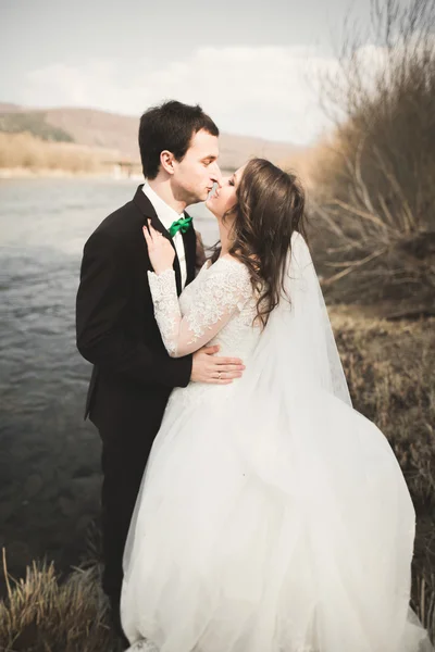 행복 한 신혼, 신부 및 신랑 아름 다운 전망 가진 강에 포즈 — 스톡 사진