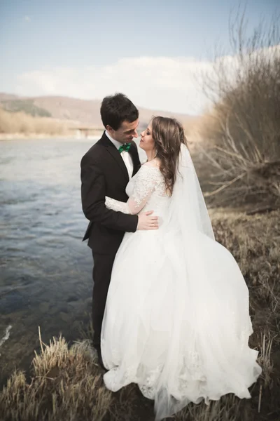 Selamat pengantin baru, pengantin pria dan wanita berpose di sungai dengan pemandangan indah — Stok Foto