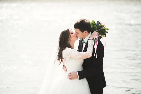 Happy newlyweds, bride and groom posing on river with beautiful views — Stock Photo, Image