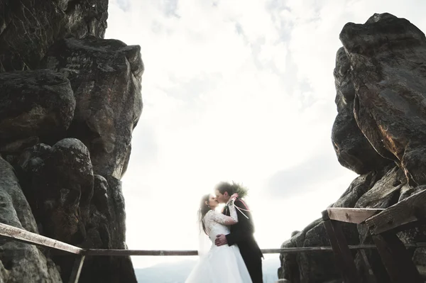 Ζευγάρι ευτυχισμένος γάμος, νύφη και ο γαμπρός που παρουσιάζουν κοντά σε βράχους με όμορφη θέα — Φωτογραφία Αρχείου