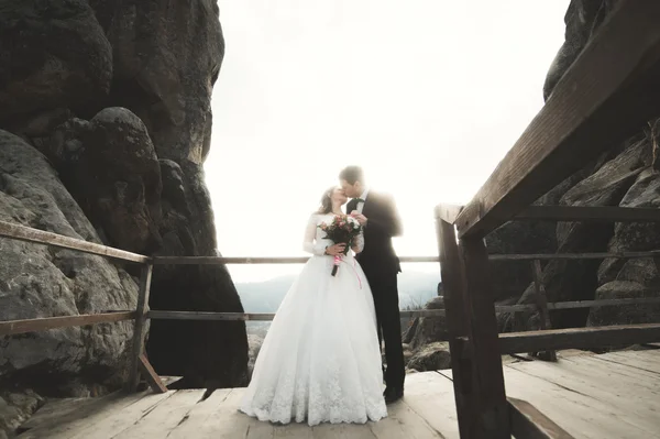 Mutlu evlilik çift, gelin ve damat kayalar güzel manzaralı yakınındaki poz — Stok fotoğraf