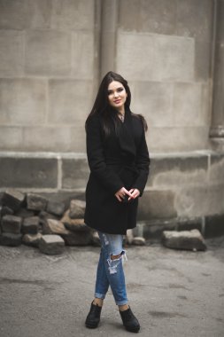 Güzel esmer genç kadın eski şehirde sokakta poz