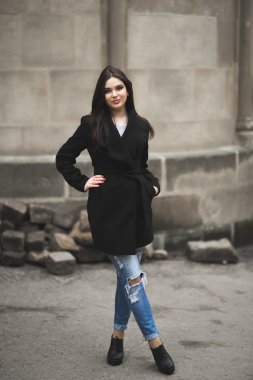 Güzel esmer genç kadın eski şehirde sokakta poz