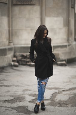 Güzel esmer genç kadın eski şehirde sokakta poz