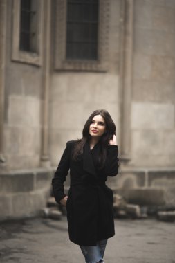 Güzel esmer genç kadın eski şehirde sokakta poz