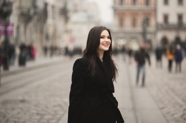 Güzel esmer genç kadın eski şehirde sokakta poz