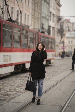 Güzel esmer genç kadın eski şehirde sokakta poz