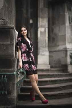 Güzel esmer genç kadın eski şehirde sokakta poz