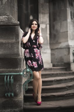 Güzel esmer genç kadın eski şehirde sokakta poz