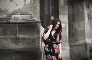 Güzel esmer genç kadın eski şehirde sokakta poz