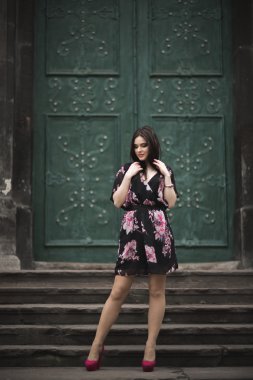 Güzel esmer genç kadın eski şehirde sokakta poz