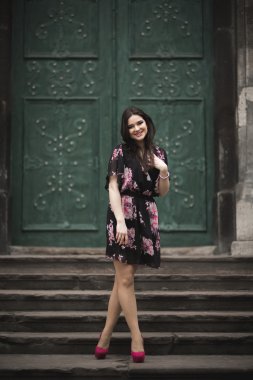 Güzel esmer genç kadın eski şehirde sokakta poz