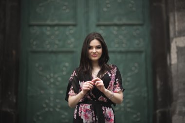 Güzel esmer genç kadın eski şehirde sokakta poz