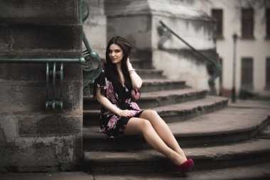 Güzel esmer genç kadın eski şehirde sokakta poz