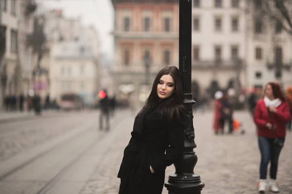 Beautiful brunette young woman posing on the street in old city — Stock Photo, Image