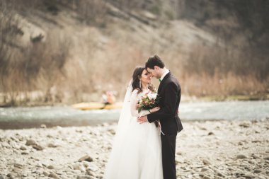 Mutlu evlilik çift, gelin ve damat zemin Dağları nın karşı temiz nehir poz