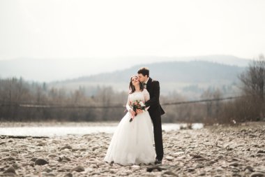 Mutlu evlilik çift, gelin ve damat zemin Dağları nın karşı temiz nehir poz