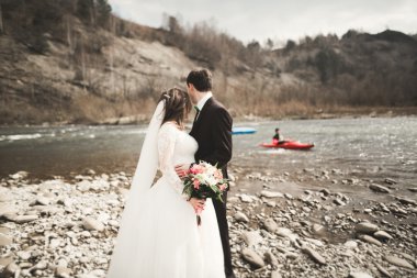 Mutlu evlilik çift, gelin ve damat zemin Dağları nın karşı temiz nehir poz