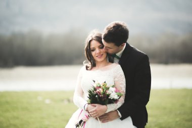 Güzel düğün çift, Gelin, poz ve yüksek Dağları arka planı alanında yürüme damat