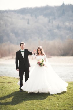 Güzel düğün çift, Gelin, poz ve yüksek Dağları arka planı alanında yürüme damat