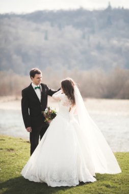 Güzel düğün çift, Gelin, poz ve yüksek Dağları arka planı alanında yürüme damat