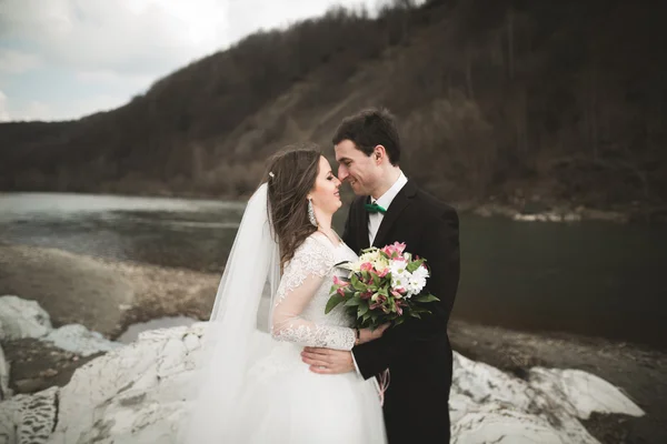 행복 한 웨딩 커플, 신부와 신랑 깔끔한 강 산의 배경으로 포즈 — 스톡 사진