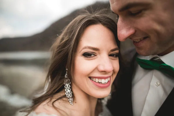 Casal de casamento feliz, noiva e noivo posando rio puro contra o pano de fundo das montanhas — Fotografia de Stock