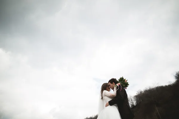 Bellissimo matrimonio coppia baciare e abbracciare vicino al fiume con pietre — Foto Stock