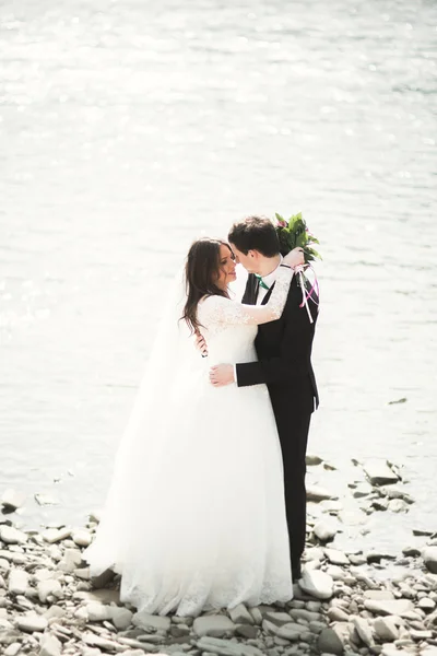 Feliz recién casados, novia y novio posando en el río con hermosas vistas —  Fotos de Stock