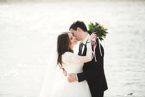Boldog ifjú házasok, a menyasszony és a vőlegény pózol a folyó gyönyörű kilátással — Stock Fotó