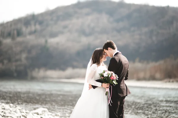 Feliz recién casados, novia y novio posando en el río con hermosas vistas —  Fotos de Stock