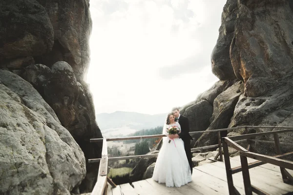 Couple de mariage amoureux embrasser et étreindre près des rochers sur un beau paysage — Photo