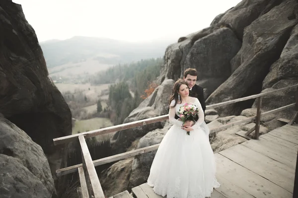 Pareja feliz boda, novia y novio posando cerca de rocas con hermosas vistas —  Fotos de Stock