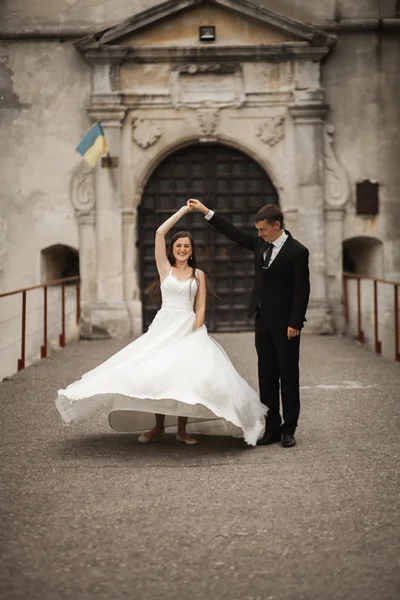 Feliz boda pareja abrazándose y sonriendo el uno al otro en el fondo hermosas plantas en el castillo — Foto de Stock