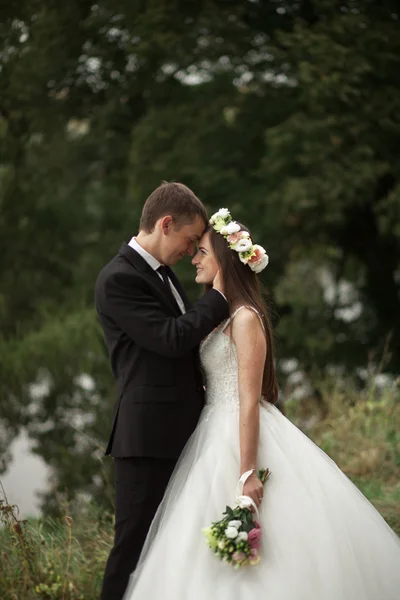 Elegante mooie bruidspaar poseren in de buurt van lake in park — Stockfoto