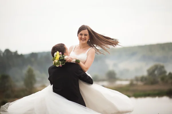 Elegante bella coppia di nozze in posa vicino al lago nel parco — Foto Stock