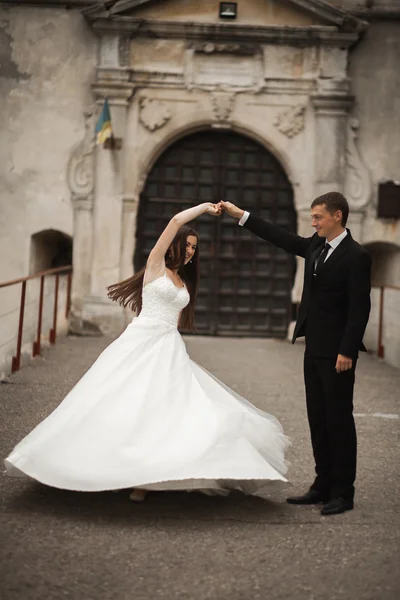 Feliz boda pareja abrazándose y sonriendo el uno al otro en el fondo hermosas plantas en el castillo — Foto de Stock