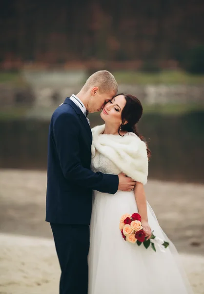 Liebe und Leidenschaft - Kuss eines verheirateten jungen Hochzeitspaares am See — Stockfoto