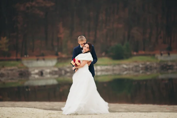Любов і пристрасть - поцілунок подружньої молодої весільної пари біля озера — стокове фото