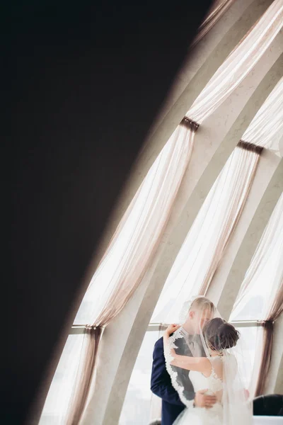 Verheugd huwelijksfeest paar, bruid en bruidegom poseren in hotel — Stockfoto