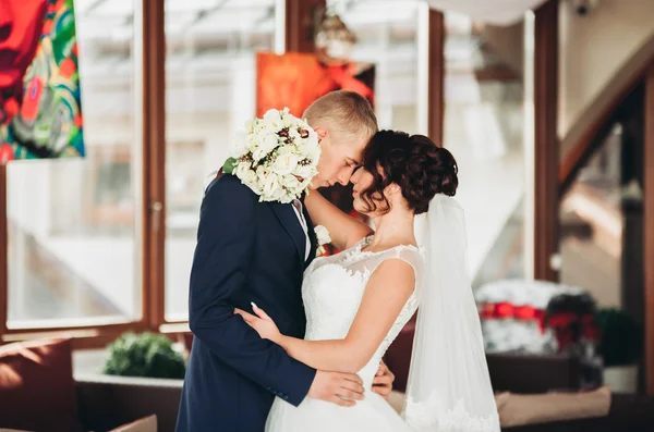 Šťastný Svatební pár, nevěsta a ženich pózuje v hotelu — Stock fotografie